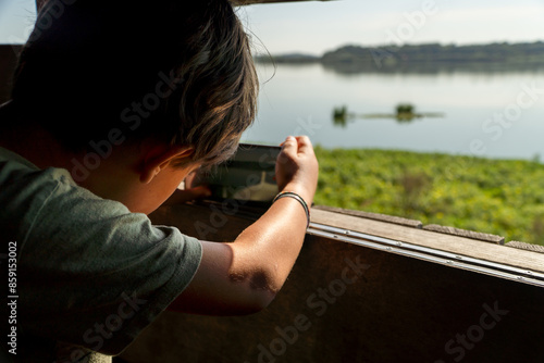 Young boy birdwatching at a natural reserve