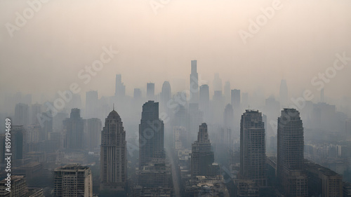 a city skyline shrouded in thick smog, with only the outlines of tall buildings visible through the haze, highlighting the severity of urban air pollution © Dark