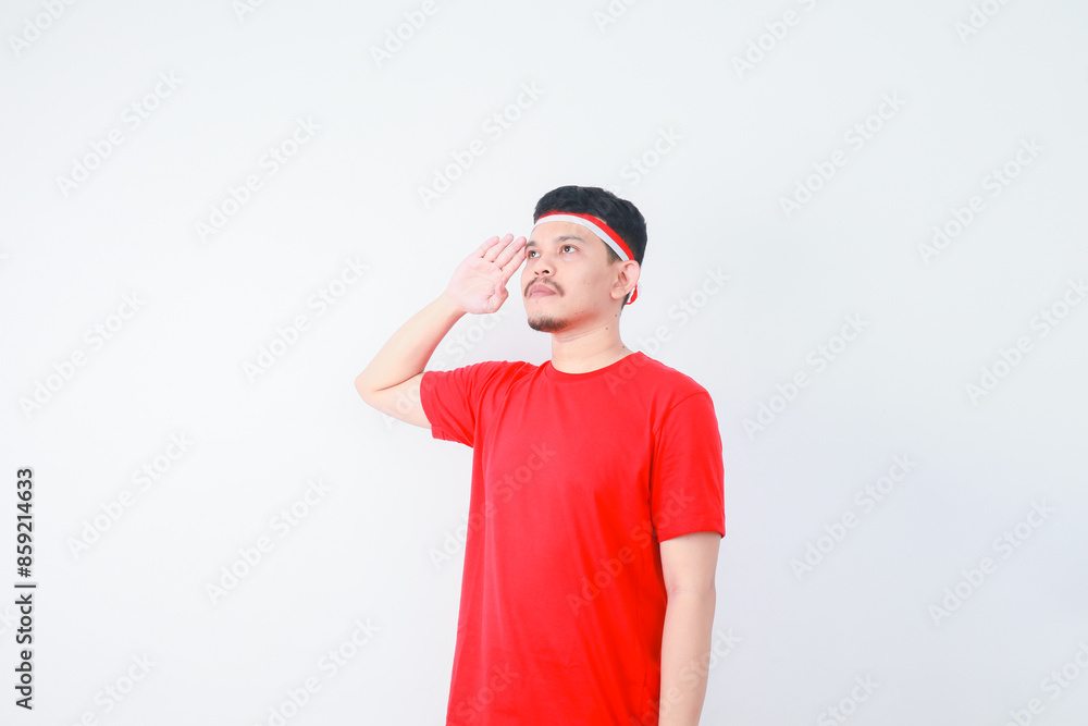 Young Asian man standing confidently giving salute and respectful gestures isolated over white background. Celebrate Indonesia independence day on 17 August Young Asian man standing confidently giving salute and respectful gestures isolated over white background. Celebrate Indonesia independence day on 17 August