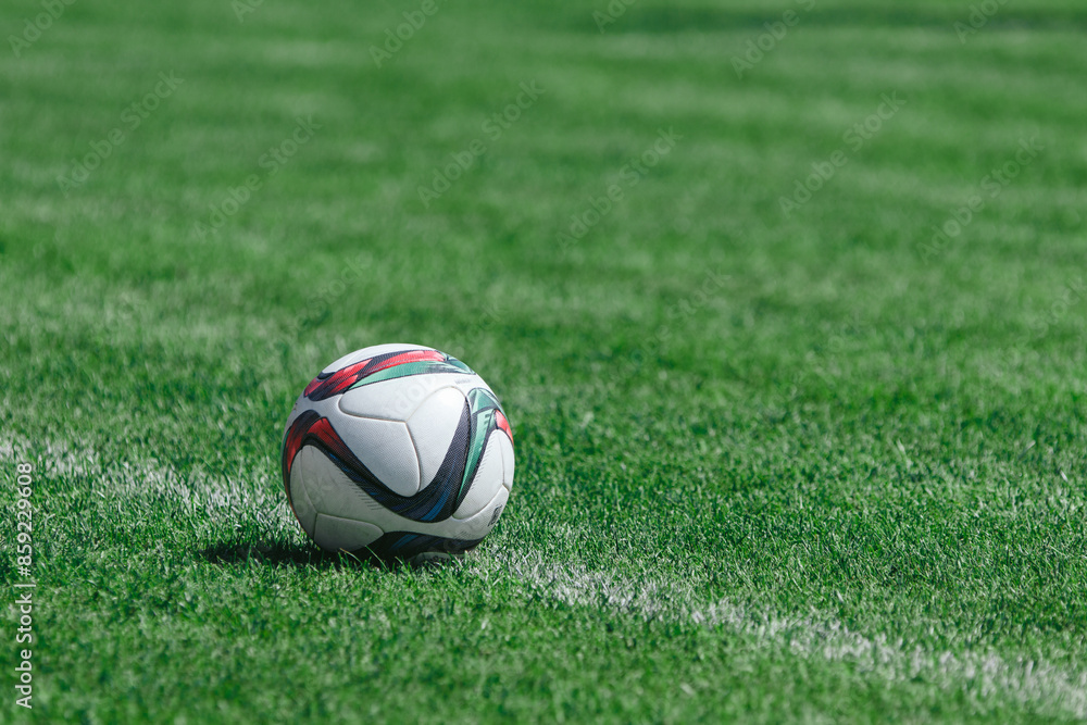A soccer ball lies on a soccer field with green grass on a white penalty line ready to be kicked by an athlete A soccer ball lies on a soccer field with green grass on a white penalty line ready to be kicked by an athlete