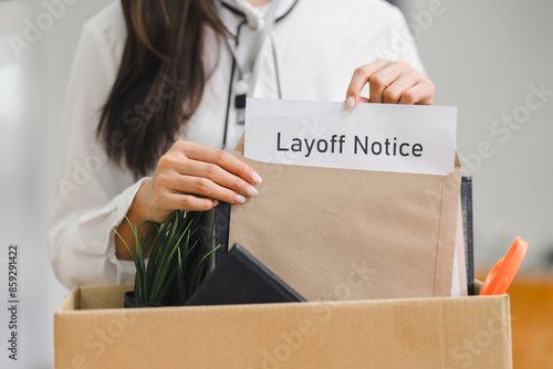 Foto Employee packing personal belongings into cardboard box after receiving layoff notice in modern office