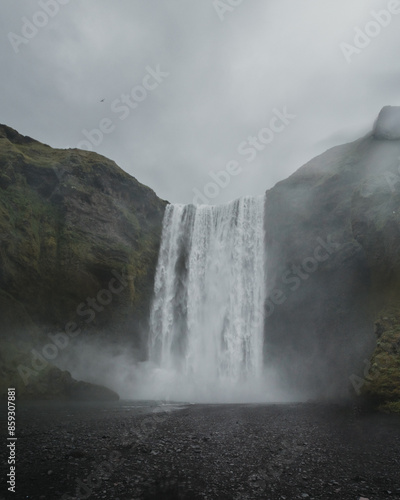 Close-up view of the powerful Skogafoss waterfall in Iceland, surrounded by mist and dramatic cliffs.