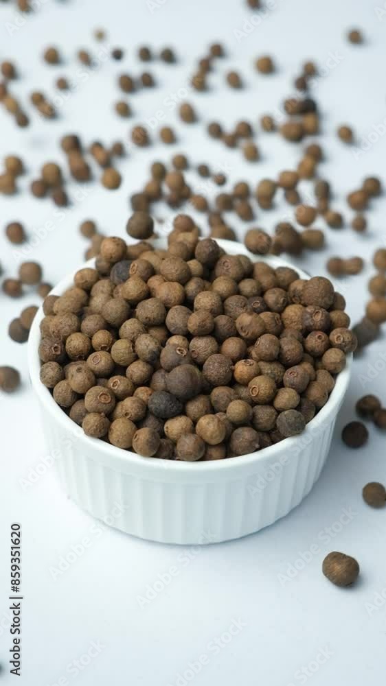 Black peppercorns pour into a plate, vertical slow motion Black peppercorns pour into a plate, vertical slow motion