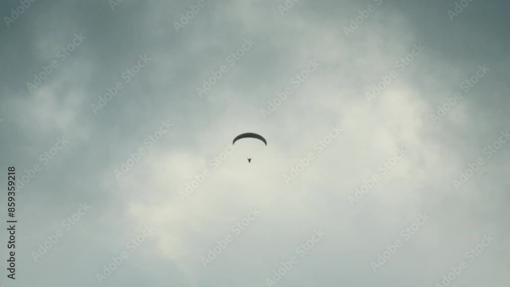 Two paragliders through the mountain fog. Paragliding during the day. Sports stimulate adrenaline. Paraglider flying through mountain fog Two paragliders through the mountain fog. Paragliding during the day. Sports stimulate adrenaline. Paraglider flying through mountain fog