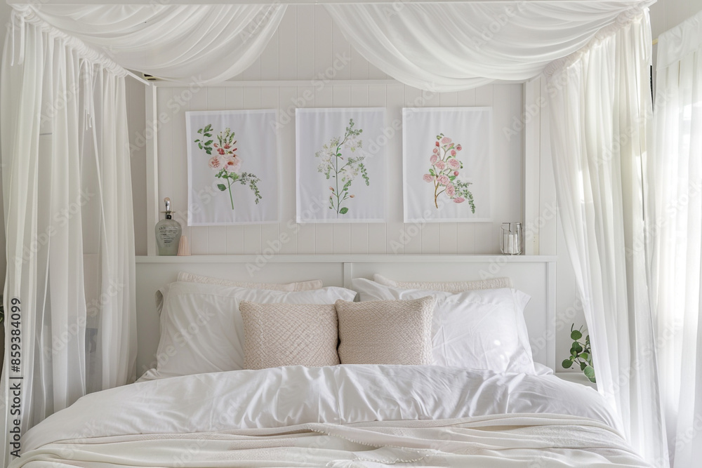 A serene white bedroom with a canopy bed, sheer curtains, and delicate floral posters above the headboard. A serene white bedroom with a canopy bed, sheer curtains, and delicate floral posters above the headboard.