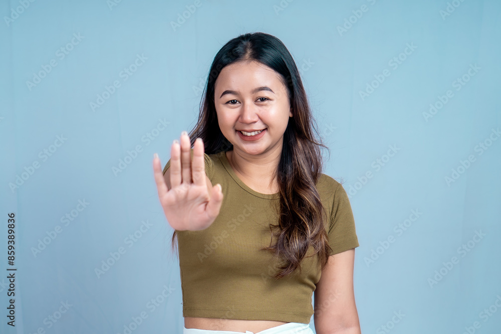 Young Asian woman wearing casual t-shirt over blue isolated background doing stop sign with palm of the hand. Young Asian woman wearing casual t-shirt over blue isolated background doing stop sign with palm of the hand.
