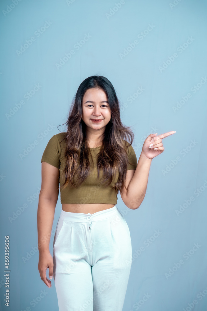 An excited young woman presents and points up the copy space, isolated on a white background An excited young woman presents and points up the copy space, isolated on a white background