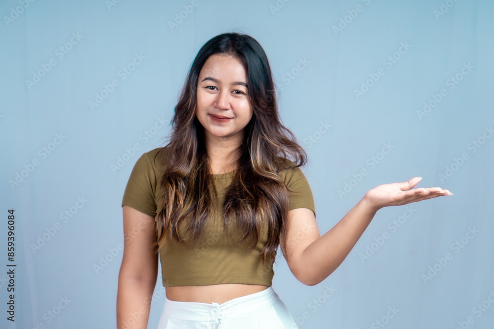 An excited young woman presents and points up the copy space, isolated on a white background An excited young woman presents and points up the copy space, isolated on a white background