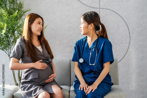 Tableau sur toile Smiling asian pregnant woman visiting doctor in prenatal clinic