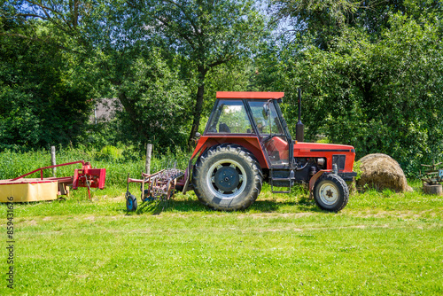 Agricultural machinery in organic farming, red tractor with a plough on the back