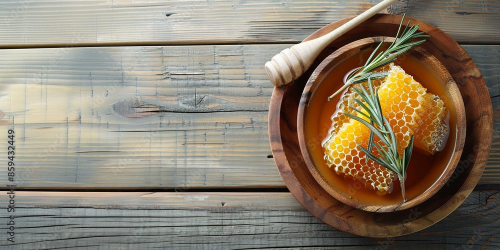 honey with rosemary combs in a wooden bowl with a spoon, on a wooden background, top view, copy space honey with rosemary combs in a wooden bowl with a spoon, on a wooden background, top view, copy space