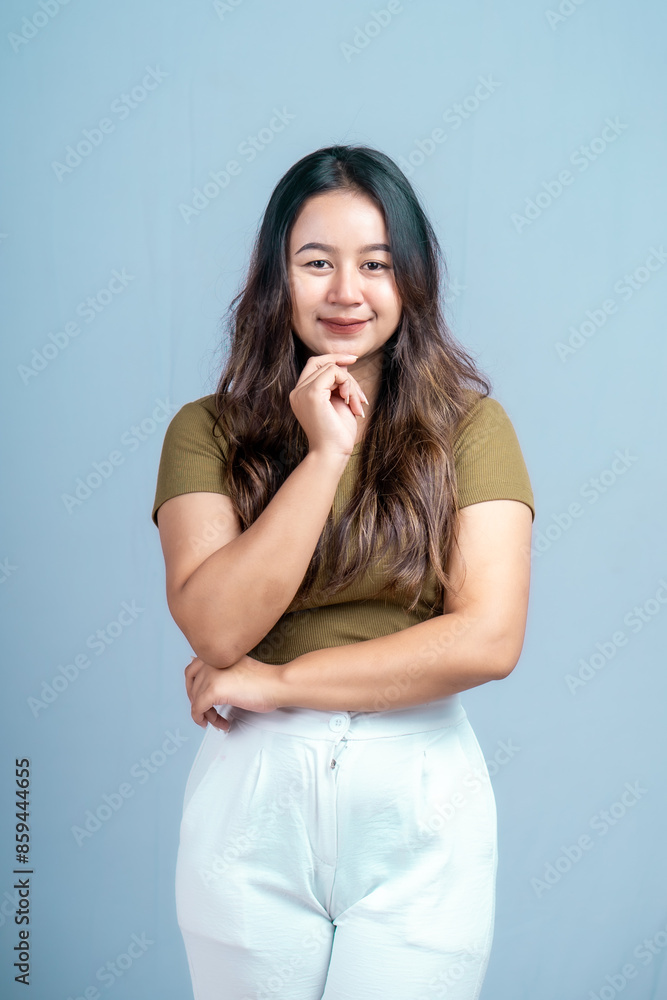 Young beautiful woman smiling joyfully and looking happy, feeling carefree and positive isolated by blue background Young beautiful woman smiling joyfully and looking happy, feeling carefree and positive isolated by blue background