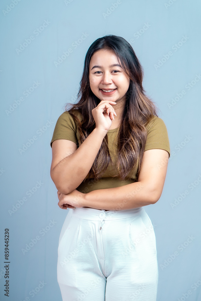Young beautiful woman smiling joyfully and looking happy, feeling carefree and positive isolated by blue background Young beautiful woman smiling joyfully and looking happy, feeling carefree and positive isolated by blue background