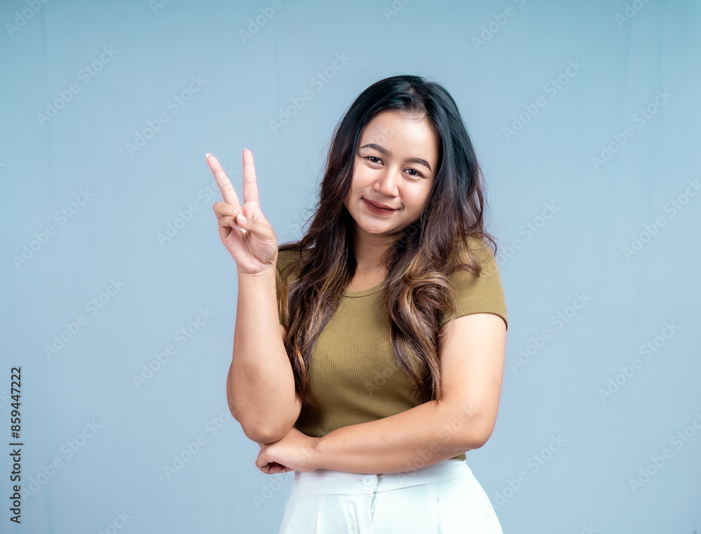 Young beautiful woman smiling joyfully and looking happy, feeling carefree and positive isolated by blue background Young beautiful woman smiling joyfully and looking happy, feeling carefree and positive isolated by blue background