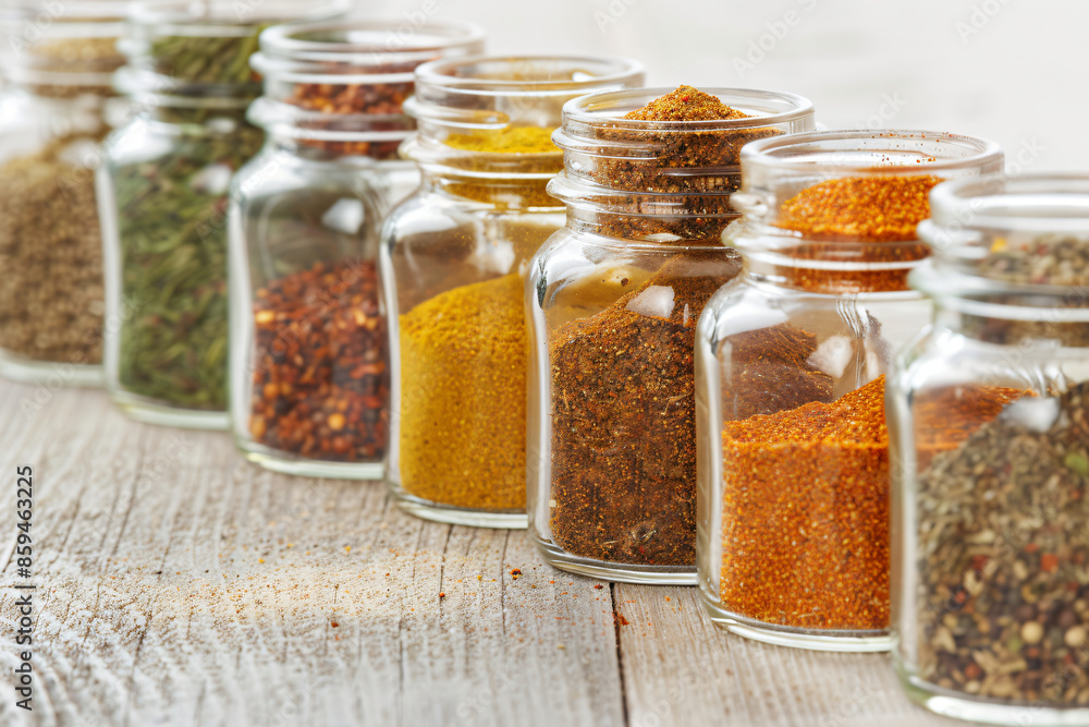 Jars with a variety of spices needed in the kitchen. Popular spices. Concept for organizing space in the kitchen. For recipe books Jars with a variety of spices needed in the kitchen. Popular spices. Concept for organizing space in the kitchen. For recipe books