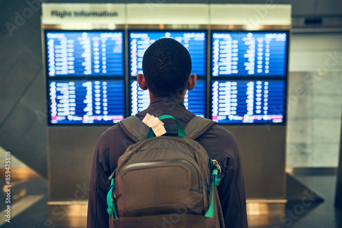 Man, back and check of timetable for flight, backpack and delay of airplane in airport and waiting room. Travel, runaway and luggage for fresh start in California, immigration or thinking of decision
