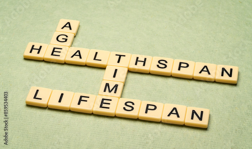 Fotografija age, time, lifespan and healthspan crossword in ivory letter tiles against textu