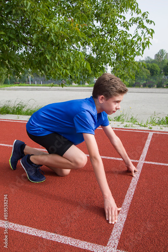 An athlete stands on the starting line at the stadium.
