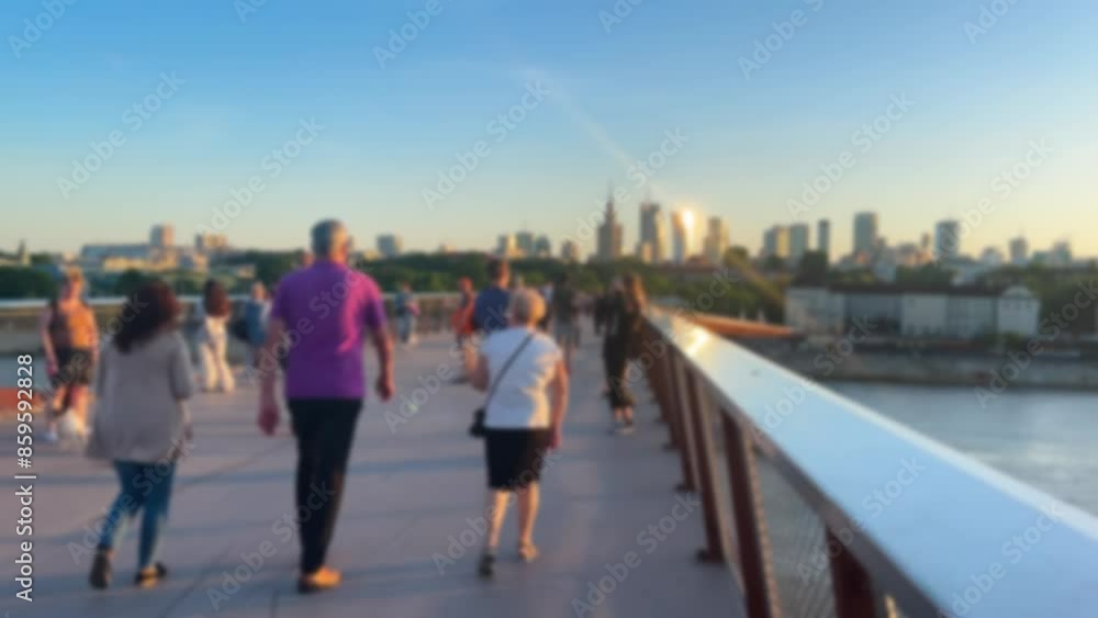 Bicycle and pedestrian bridge over the Vistula. Warsaw, Poland. People take selfies and take pictures against the backdrop of the city and the river. Out of focus. Bicycle and pedestrian bridge over the Vistula. Warsaw, Poland. People take selfies and take pictures against the backdrop of the city and the river. Out of focus.