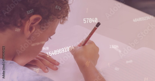 Image of numbers over biracial schoolboy writing