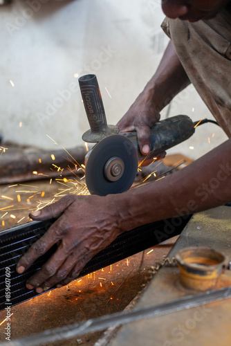 Man is working at metal factory, he is welding a piece of rail using special tools. photo