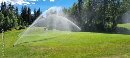 sprinklers on golf greene in summmer with clear blue sky and warming sunshine in mosjøen nordland