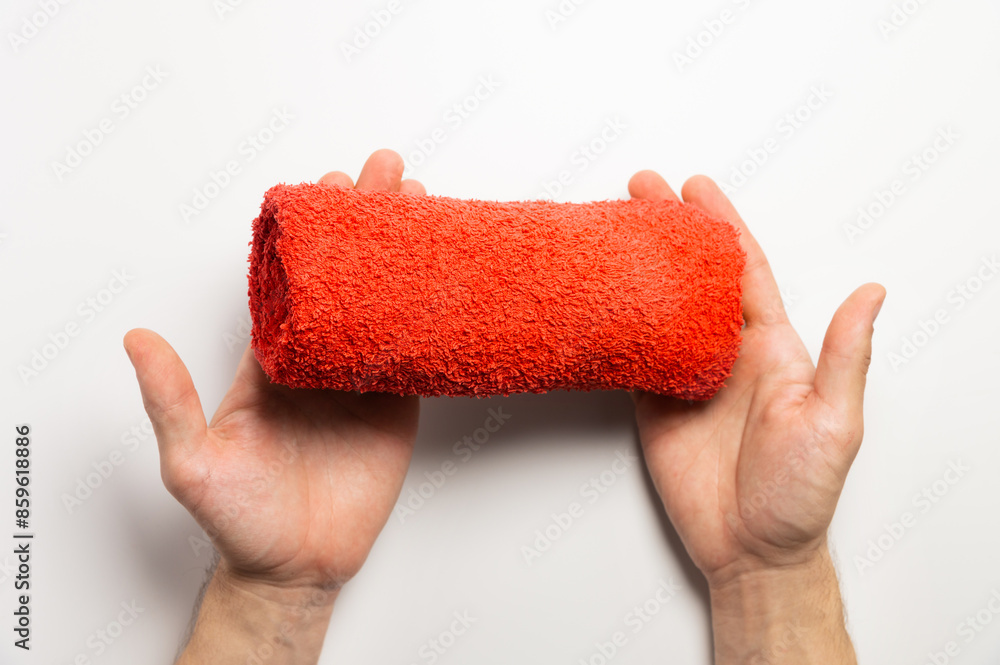 Male hands holding a folded red towel on a white background Male hands holding a folded red towel on a white background