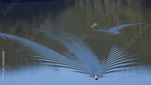 bateau de pêche avec sillage sur l'eau sur le barrage des Fades sur la rivière Sioule dans le Puy-de-Dôme photo