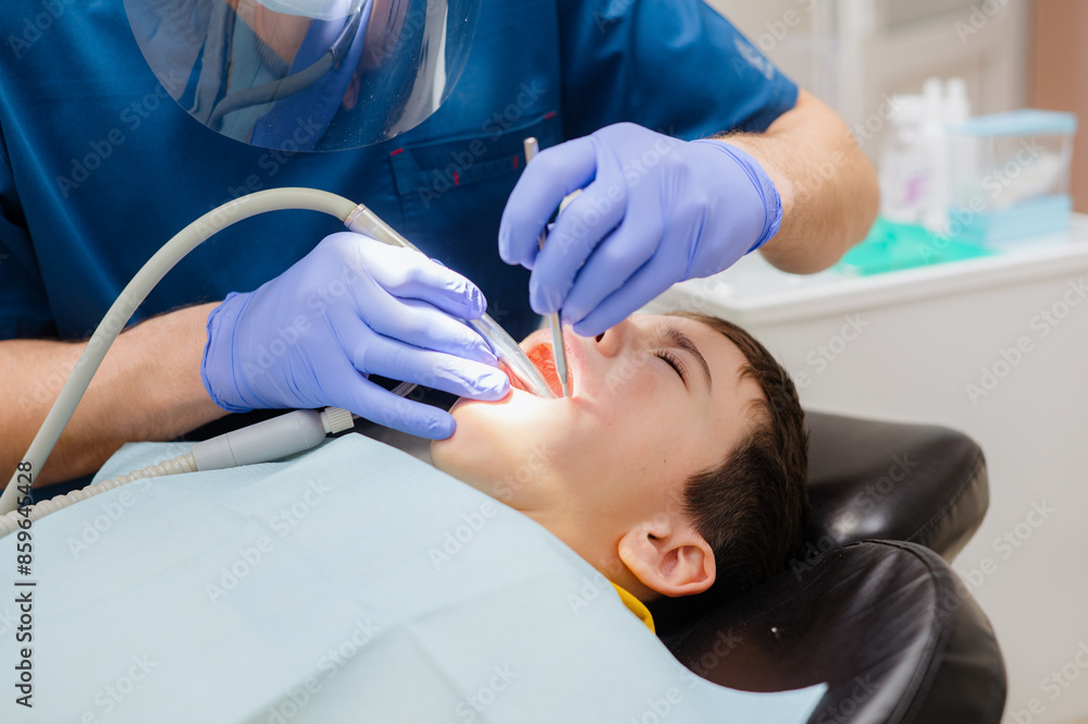 Cute little boy is sitting in a dental chair with a scared expression on his face, afraid to treat his teeth. Prevention of diseases of baby teeth in children. Cute little boy is sitting in a dental chair with a scared expression on his face, afraid to treat his teeth. Prevention of diseases of baby teeth in children.