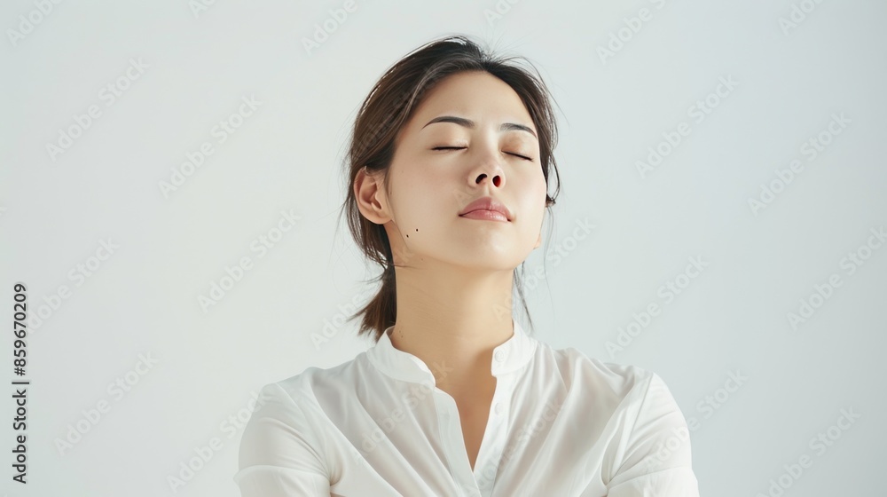 Asian woman is sitting with her head tilted to the side while her eyes closed