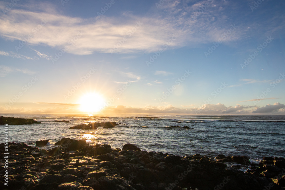 Sunrise over the sea with light waves. Sand beach with lava rocks and blue water alternate with blue water. Island in the Indian Ocean, beach out of the blue, Trou d’Eau Douce, Mauritius, Africa Sunrise over the sea with light waves. Sand beach with lava rocks and blue water alternate with blue water. Island in the Indian Ocean, beach out of the blue, Trou d’Eau Douce, Mauritius, Africa