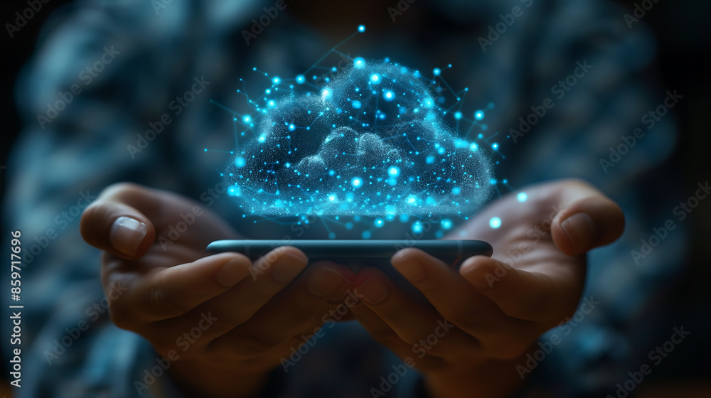 A person holding a smartphone with a glowing cloud technology icon on the screen, in a close-up view of the hands and phone in the foreground against a dark background. A person holding a smartphone with a glowing cloud technology icon on the screen, in a close-up view of the hands and phone in the foreground against a dark background.