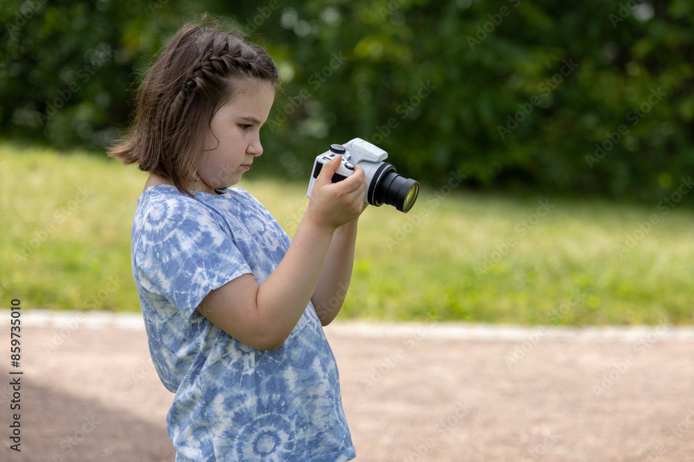 A little girl takes a pictures of nature with a camera A little girl takes a pictures of nature with a camera