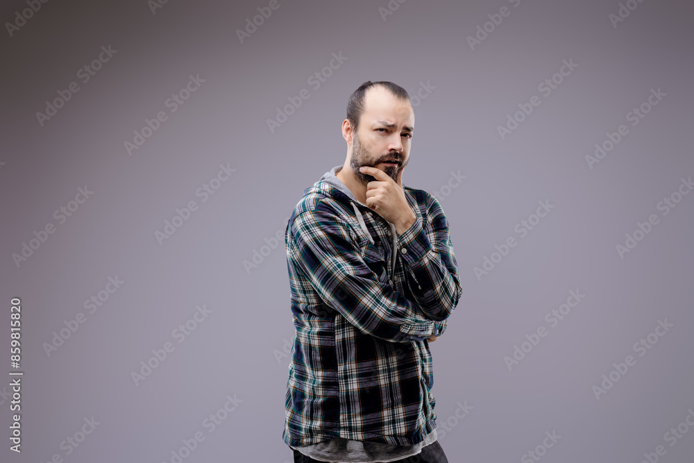 Thoughtful bearded man touching chin on grey background Thoughtful bearded man touching chin on grey background