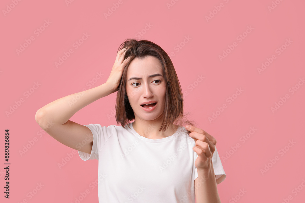 Emotional woman holding clump of lost hair on pink background. Alopecia problem Emotional woman holding clump of lost hair on pink background. Alopecia problem