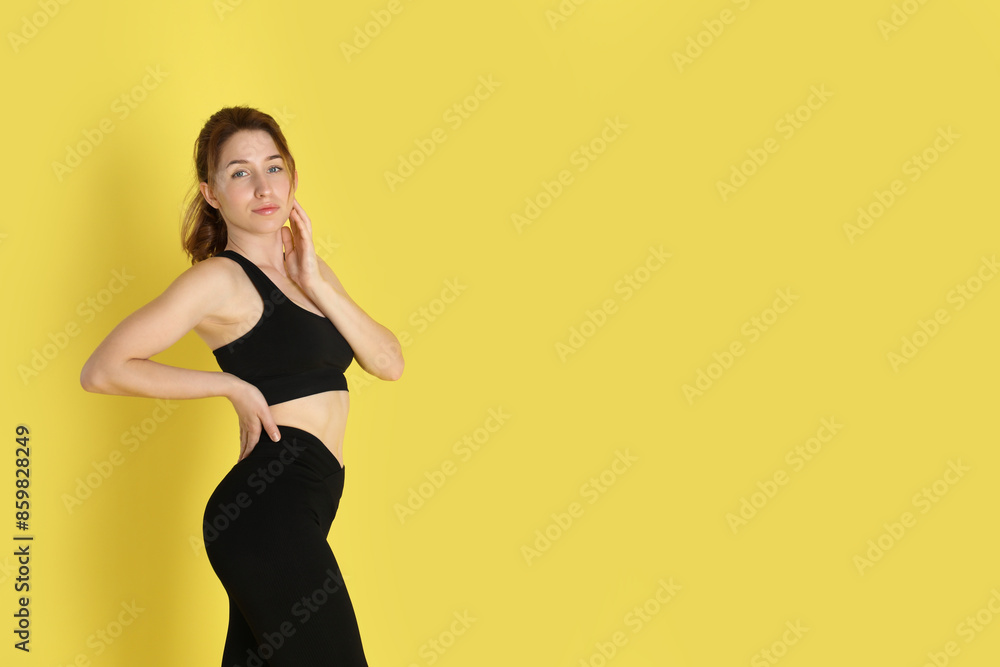 Woman with slim body posing on yellow background, space for text Woman with slim body posing on yellow background, space for text