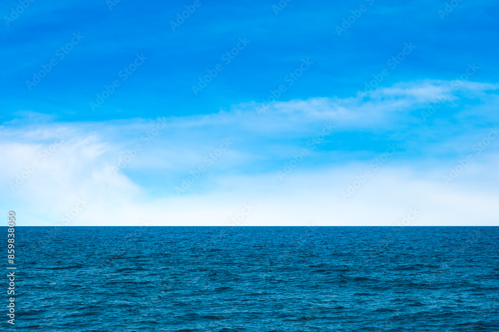 Obraz premium Ocean background and sea water and clear sky. For summer vacation ideas The nature of the beach and summer sea with the sun shining on the sea sparkling against the blue sky.