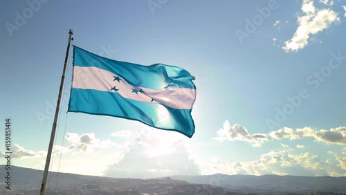 Flag of Honduras with the sun in the background in a sunset