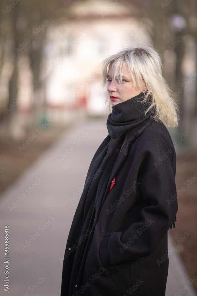Portrait of a young beautiful blonde girl in a dark coat. Portrait of a young beautiful blonde girl in a dark coat.