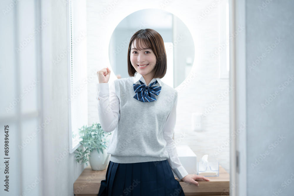鏡の前でガッツポーズをする女子高生