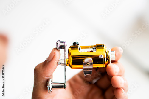 Hand holding a small gold fishing reel