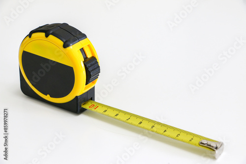 A black and yellow retractable tape measure held in place at 10 cm, measuring length, width and height concept, accuracy and precision