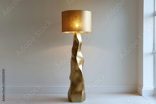 Sophisticated floor lamp with a gold leaf finish and a silk drum shade, positioned in the corner of a room with a plain white backdrop