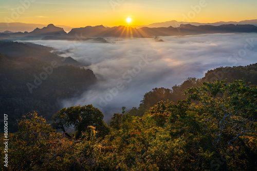 Sunrise behind mountain range with sea of cloud and cliff in the northern of Thailand (Landscape photography, Beautiful sunflare)