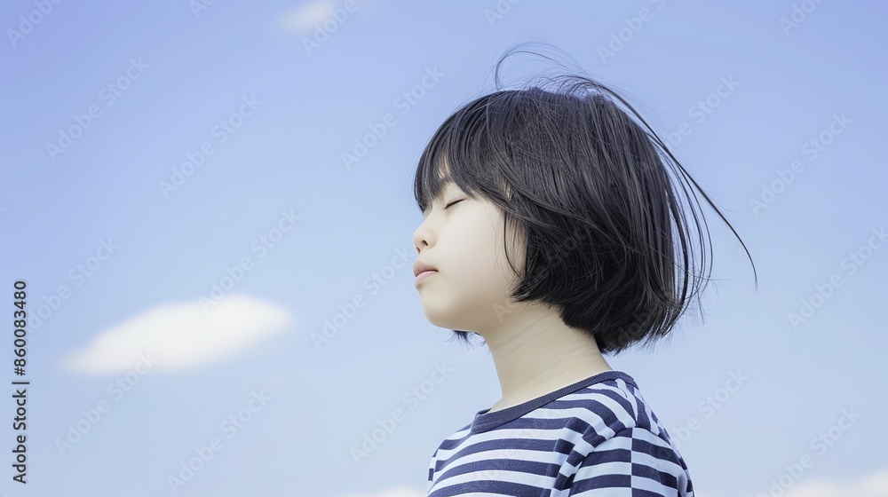 Serene young Asian girl with closed eyes standing under clear blue sky Serene young Asian girl with closed eyes standing under clear blue sky