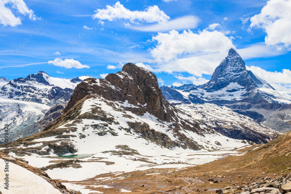 Fototapeta premium Scenic view on snowy Matterhorn mountain peak in sunny day with blue sky in Switzerland. Beautiful nature background of Swiss Alps covered with snow. Famous travel destination
