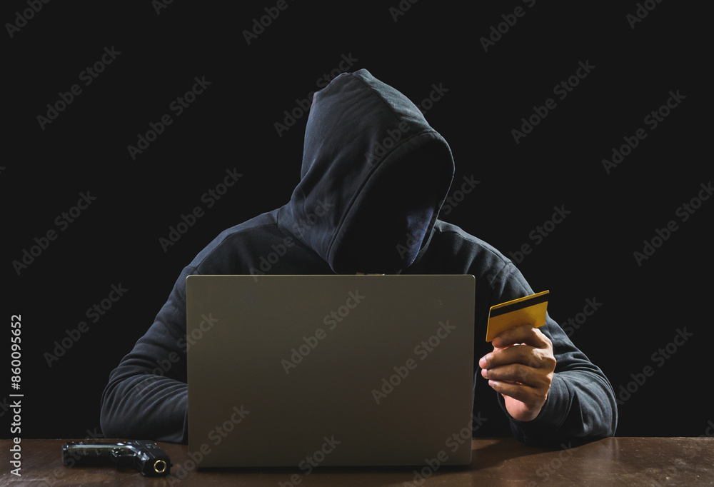 Portrait hacker spy man one person in black hoodie sitting on table looking computer laptop used login password attack security to data digital internet network system night dark background copy space Portrait hacker spy man one person in black hoodie sitting on table looking computer laptop used login password attack security to data digital internet network system night dark background copy space