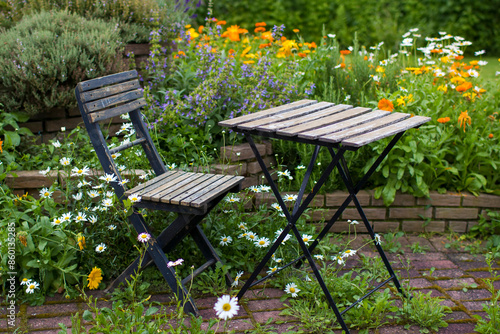 herb spiral in the garden with fresh herbs and flowers