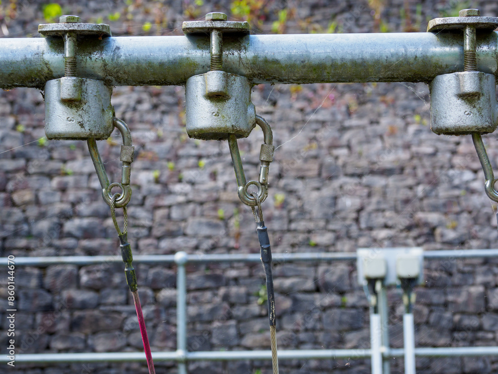 Industrial machinery close-up with metal components against a brick wall background.