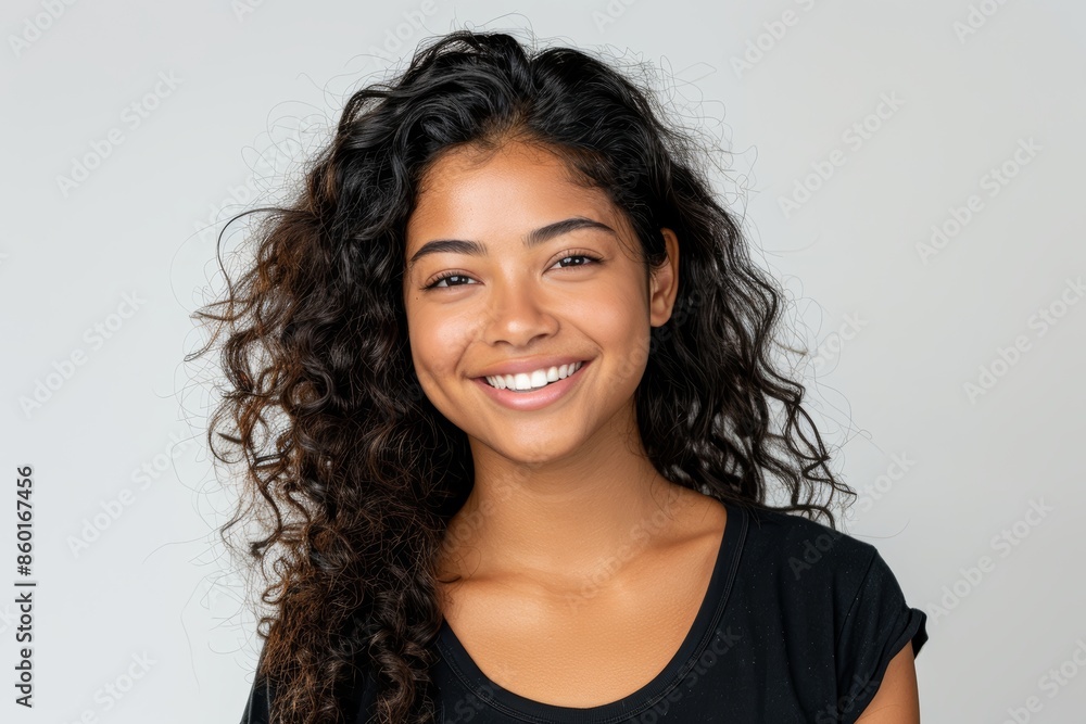 A portrait of a young woman with long curly hair smiling at the camera A portrait of a young woman with long curly hair smiling at the camera